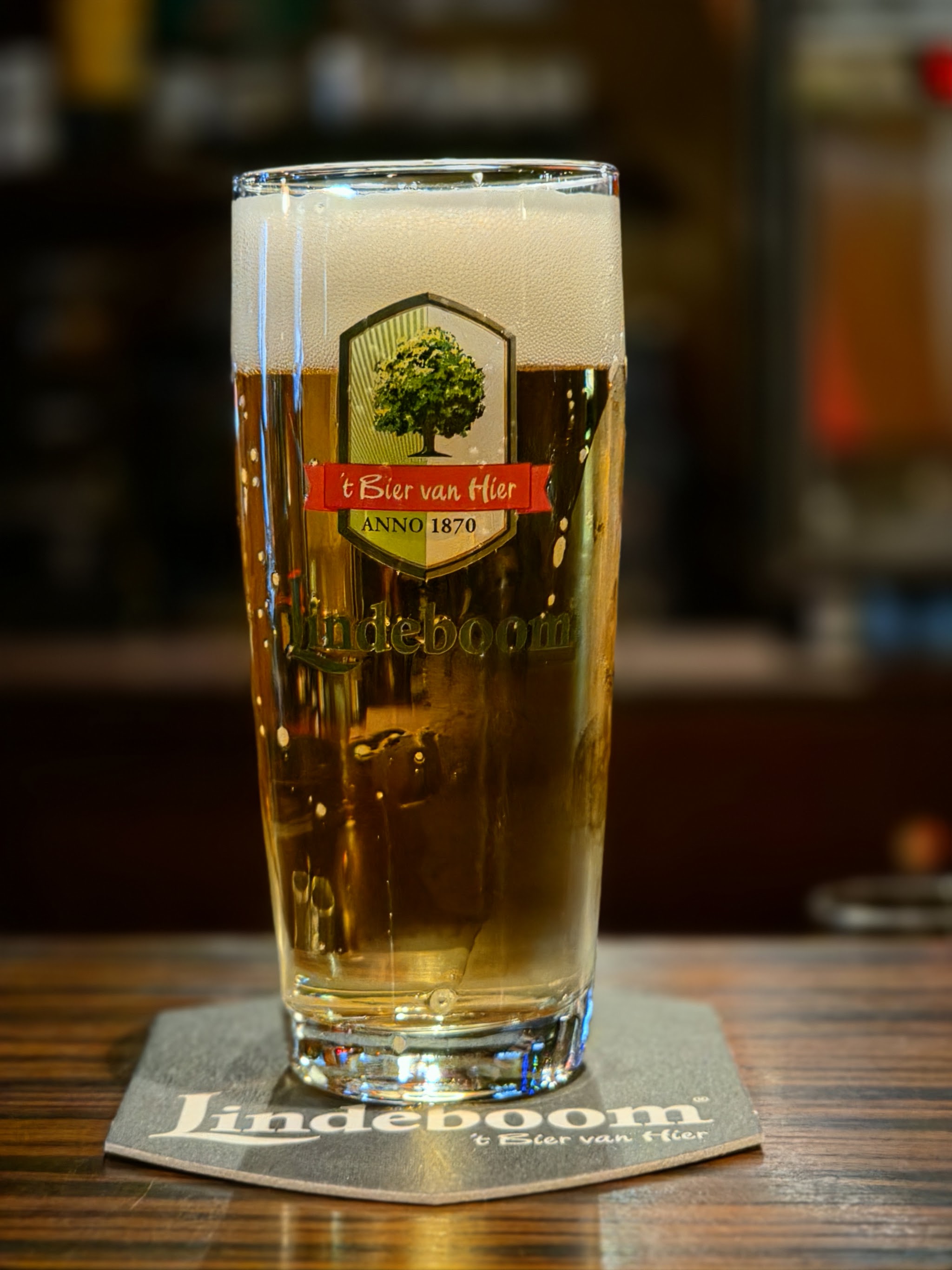 Een vers getapt glas Lindeboom op de houten bar